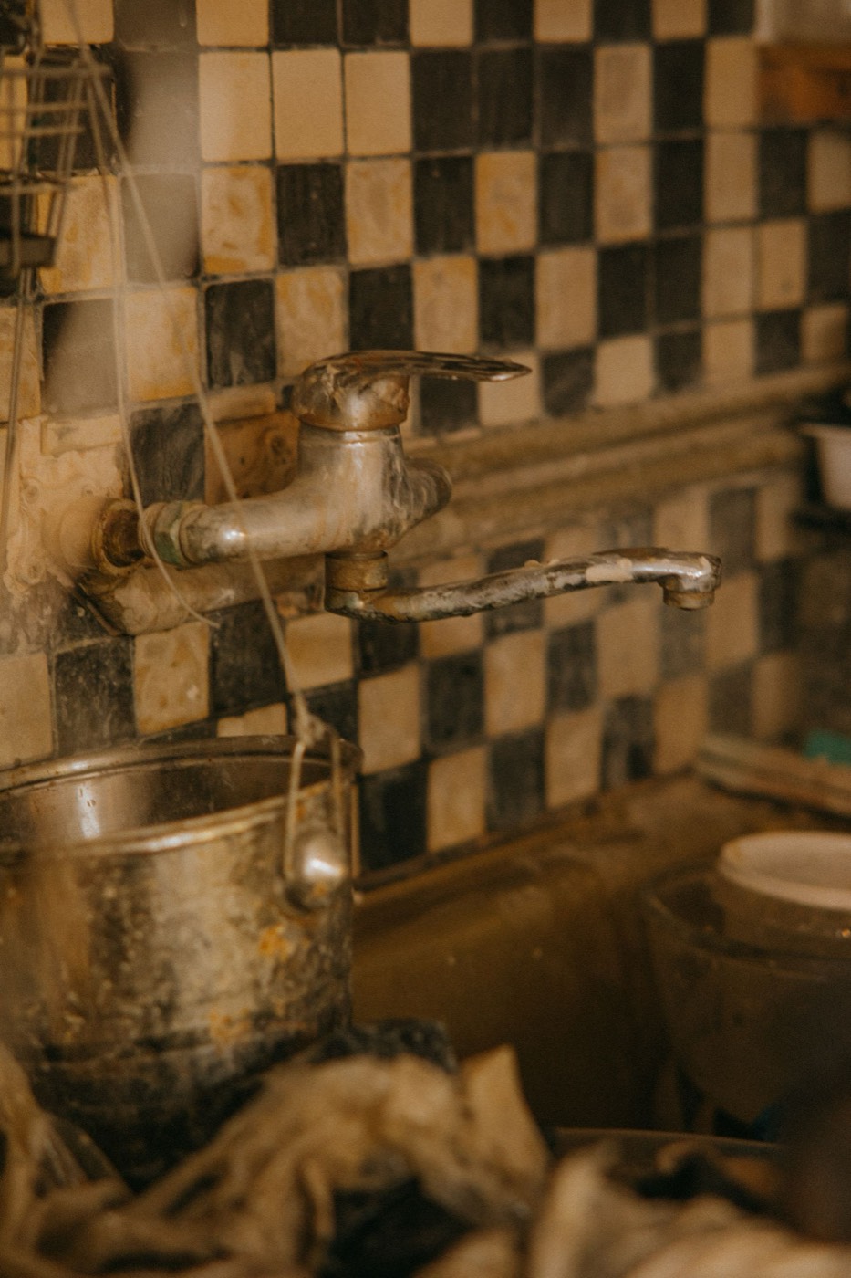 Hard water scale and grime built up on an old kitchen faucet