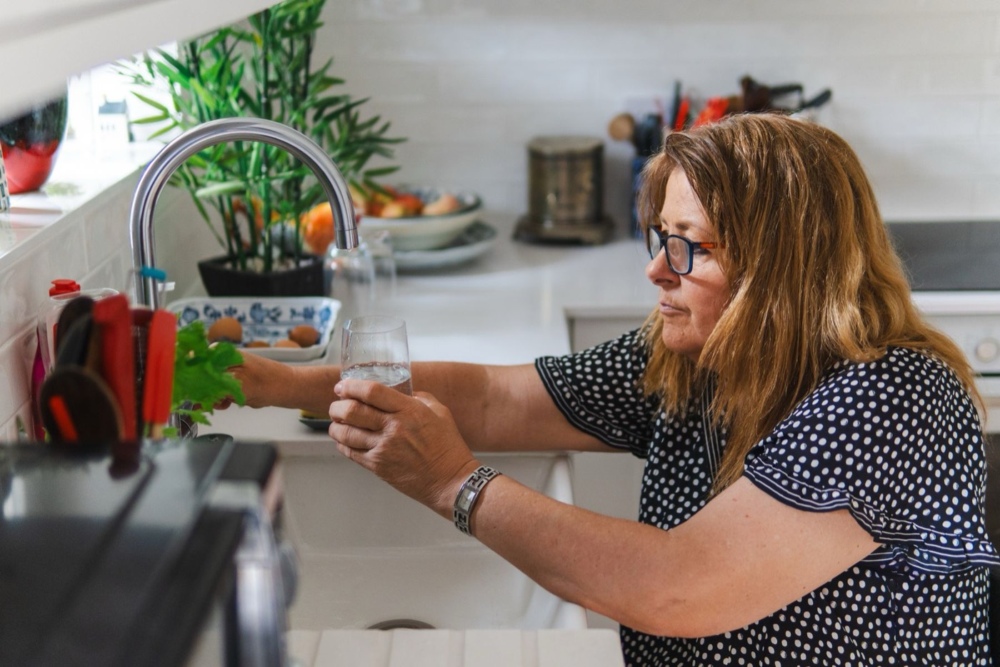 Homeowner filling a glass of water at the kitchen tap